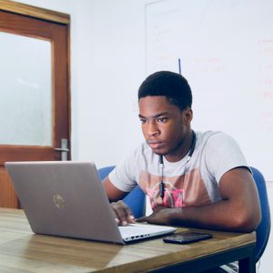 Boy sitting at laptop in classroom